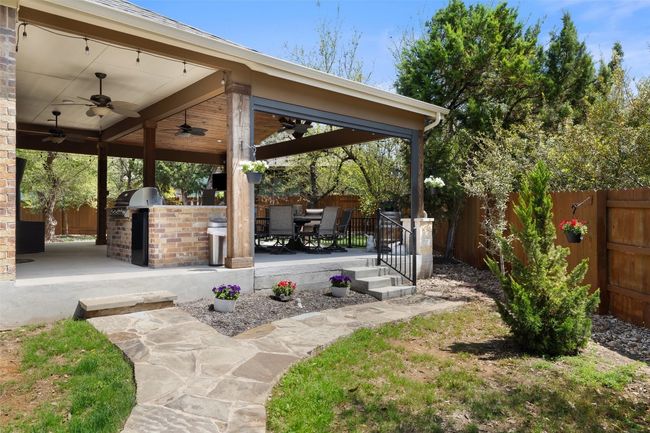 A private backyard retreat featuring lush landscaping, mature trees, and extended storage areas for enhanced privacy and everyday functionality | Image 24