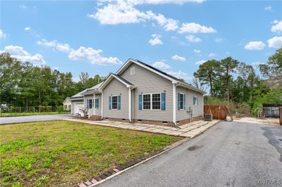 View of front of home featuring a front lawn, central AC unit, and a garage | Image 2