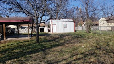 View of yard with a carport and a storage shed | Image 2