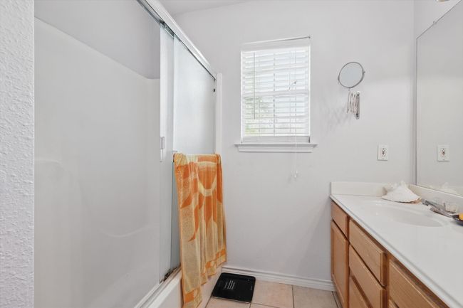 Full bathroom featuring a shower with door, tile patterned floors, vanity, and baseboards | Image 24