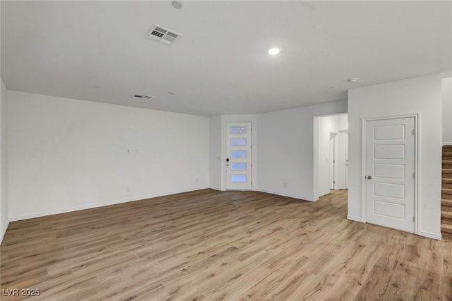 Empty room featuring baseboards, visible vents, stairway, and light wood-style floors | Image 11