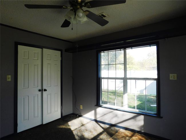 Unfurnished bedroom with ceiling fan, a closet, and a textured ceiling | Image 23