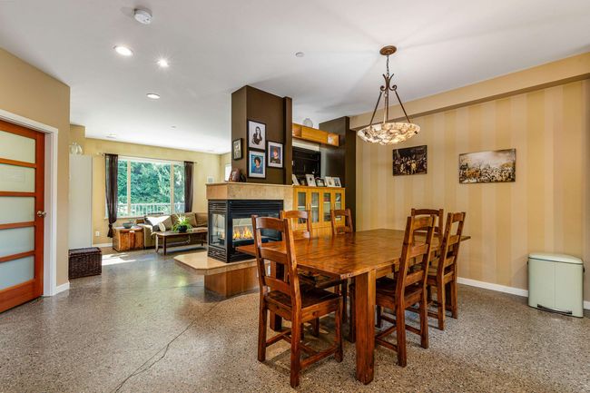 Dining room featuring a fireplace, speckled floor, and recessed lighting | Image 6
