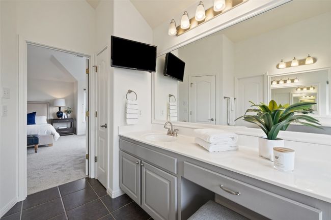 Bathroom with lofted ceiling, dark tile patterned flooring, vanity, and ensuite bathroom | Image 28