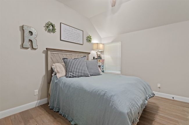 Bedroom with wood finished floors, lofted ceiling, and ceiling fan | Image 12