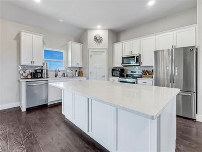 Kitchen with a kitchen island, stainless steel appliances, dark hardwood / wood-style flooring, and white cabinetry | Image 2