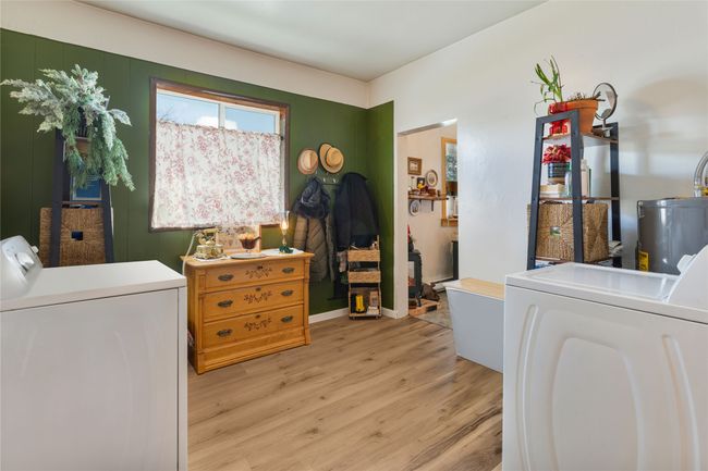 Laundry area featuring water heater, washer and dryer, light wood finished floors, and laundry area | Image 17