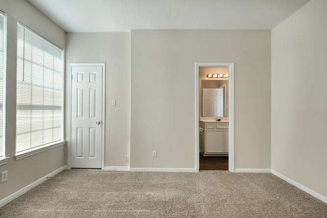 Unfurnished bedroom with carpet flooring, baseboards, and ensuite bathroom | Image 8