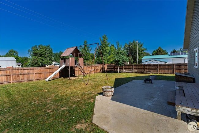 Backyard, patio, playset and garden area in far corner. | Image 14