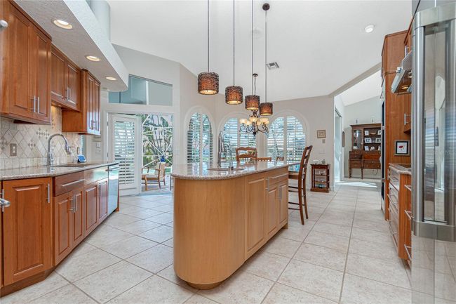 Cherry and maple wood cabinets with Silestone counters and pull out drawers. Center island includes a vegetable sink | Image 10