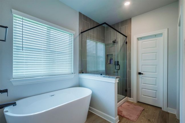 Bathroom featuring wood finished floors, a freestanding tub, and a shower stall | Image 17