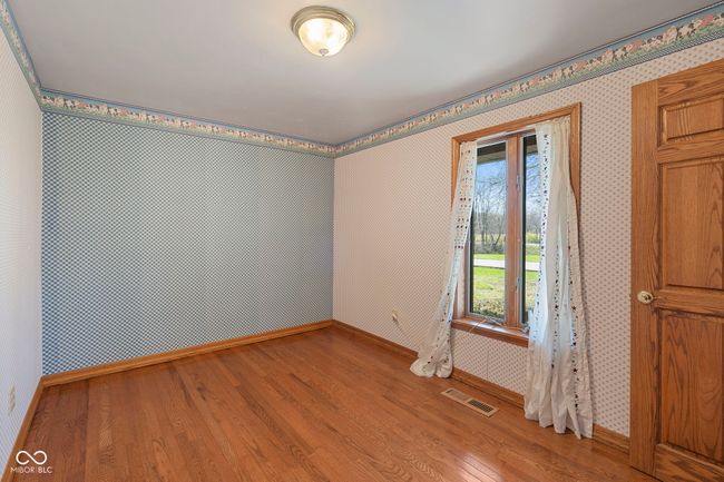 spare room featuring wood finished floors, baseboards, and wallpapered walls | Image 17