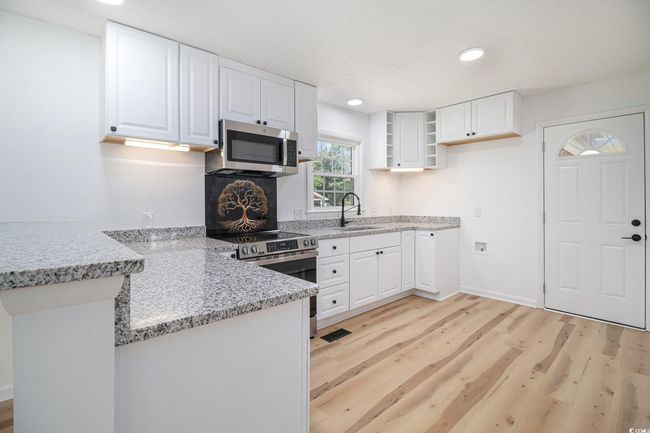 The kitchen features all new stainless steel GE appliances including a range, dishwasher, microwave, garbage disposal, and refrigerator. | Image 14