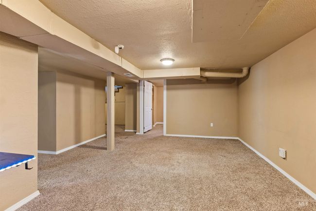 Finished below grade area with a textured ceiling and light carpet | Image 33