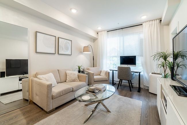 Living room with baseboard heating and dark wood finished floors | Image 7