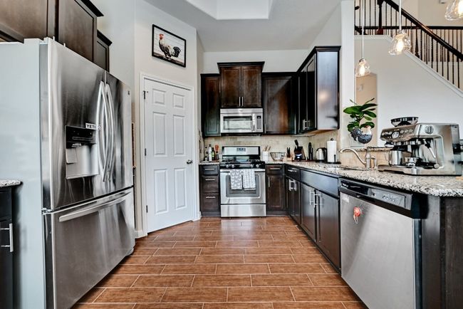 The kitchen is open and airy, features stainless steel appliances and recessed lighting | Image 7
