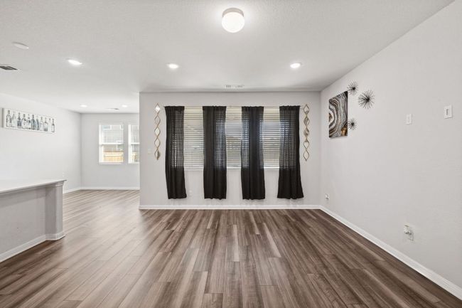 Unfurnished room featuring baseboards, wood finished floors, visible vents, and recessed lighting | Image 12