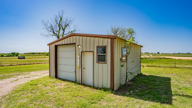 View of outbuilding with a rural view, an outbuilding, fence, and dirt driveway | Image 28