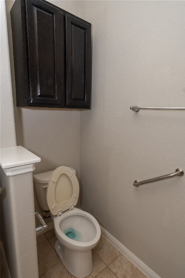 Bathroom with toilet, tile patterned floors, and baseboards | Image 11