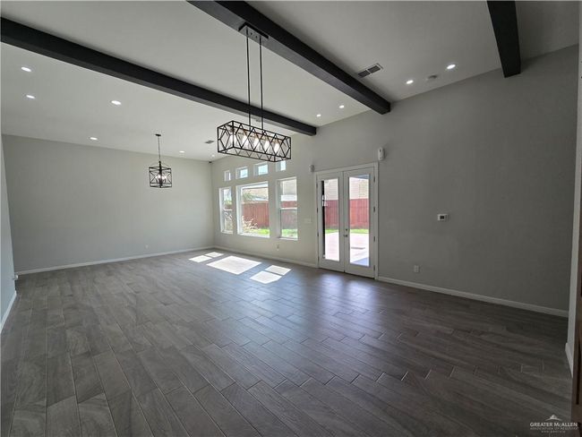 Unfurnished room featuring beam ceiling, recessed lighting, baseboards, dark wood-style floors, and a chandelier | Image 7