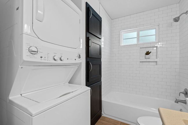 Bathroom with stacked washer / drying machine, bathing tub / shower combination, and vanity | Image 34