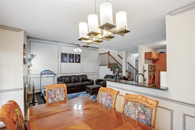Dining space featuring ceiling fan, stairway, and a decorative wall | Image 6