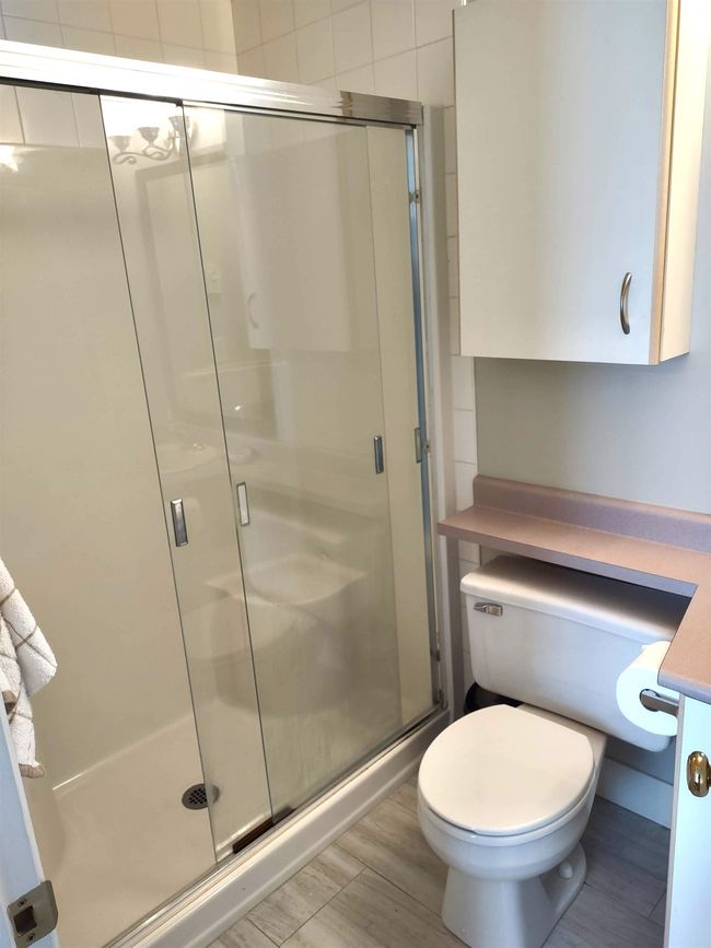Bathroom with toilet and a stall shower | Image 14