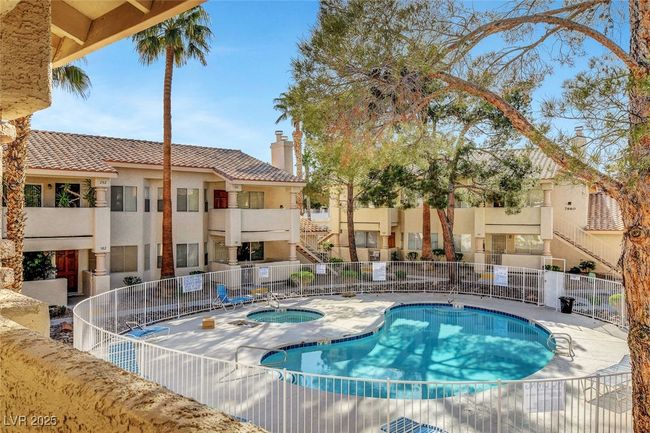 View of swimming pool with a community hot tub and fence | Image 27