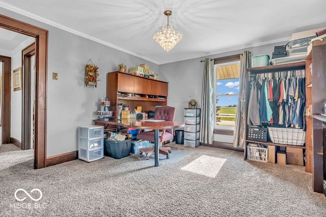 home office featuring carpet flooring, ornamental molding, and a chandelier | Image 33