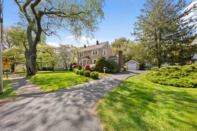 The driveway offers ample parking, along with a 1-car detached garage, and separate concrete pad with firewood storage and room for an extra vehicle. | Image 2