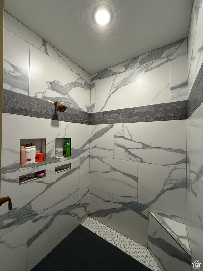 Full bathroom featuring a marble finish shower and a textured ceiling | Image 37