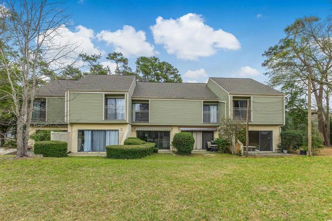 Rear view of house with a lawn, stucco siding, and a balcony | Image 29