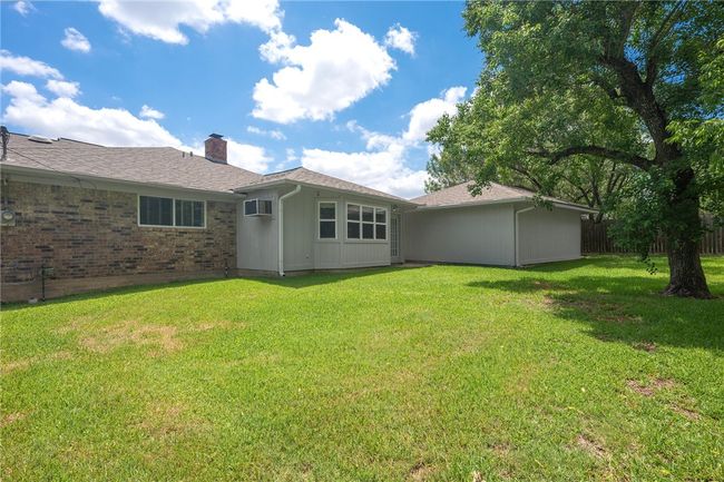 Rear view of house with a chimney and a wall unit AC | Image 20