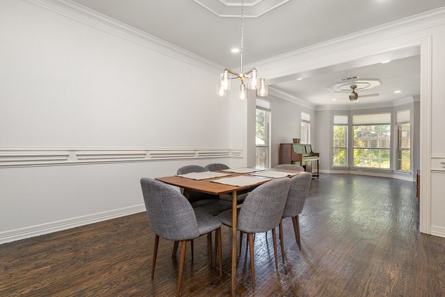 Dining area with wood floors, chandelier and chair rail | Image 5