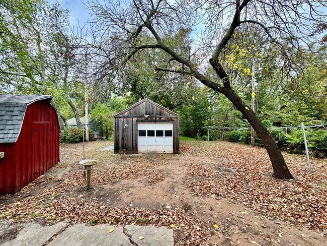 View of yard with a detached garage, an outdoor structure, and view of scattered trees | Image 25