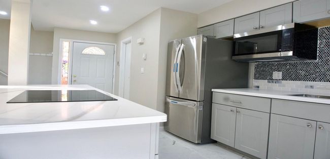 Kitchen with tasteful backsplash, stainless steel appliances, marble finish floor, and gray cabinets | Image 18