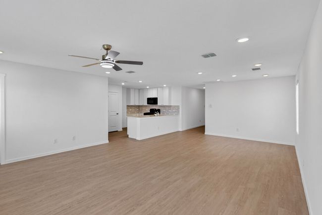 Unfurnished living room with recessed lighting, baseboards, a ceiling fan, and light wood-style floors | Image 6