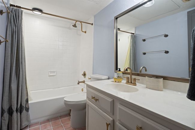 Bathroom featuring vanity, tile patterned flooring, toilet, and shower / tub combo with curtain | Image 24