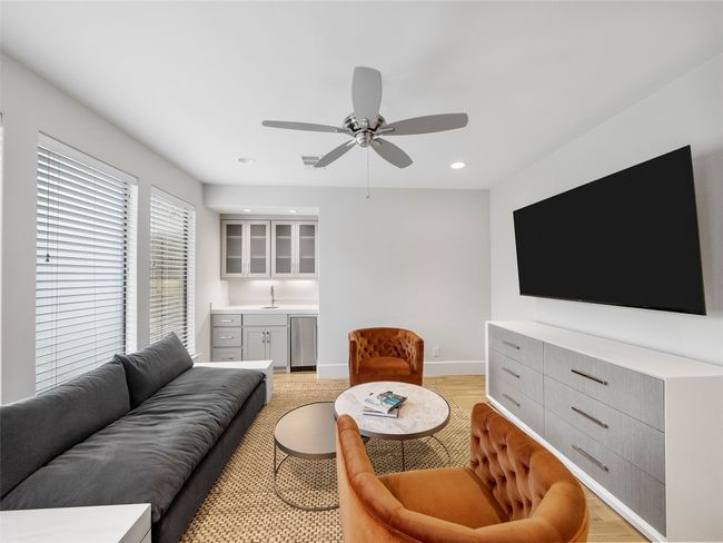 Living area featuring light wood finished floors, bar, ceiling fan, and recessed lighting | Image 33