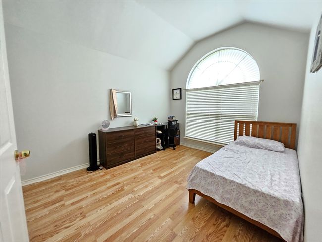 Bedroom with lofted ceiling and light wood-type flooring | Image 27