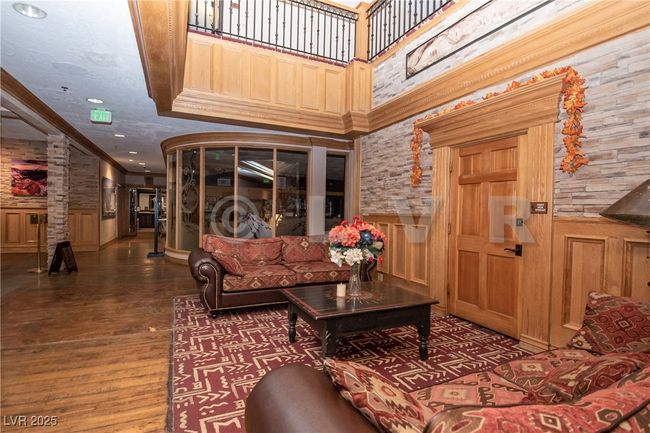 Living area featuring wainscoting, crown molding, wood finished floors, decorative columns, and recessed lighting | Image 22