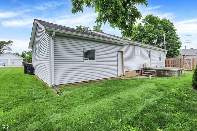back of house featuring a detached garage and a shingled roof | Image 24