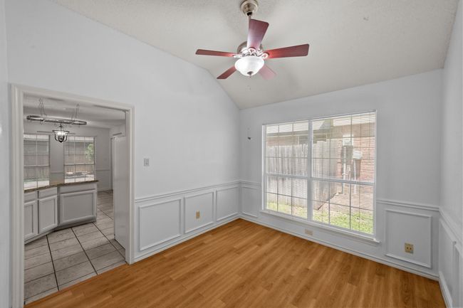 Featuring vaulted ceiling with fan, a wainscoted wall, wood-style floors, and a decorative molding | Image 19