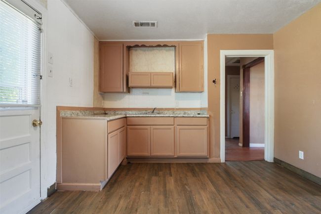 Kitchen with baseboards, dark wood-style flooring, light countertops, and visible vents | Image 7
