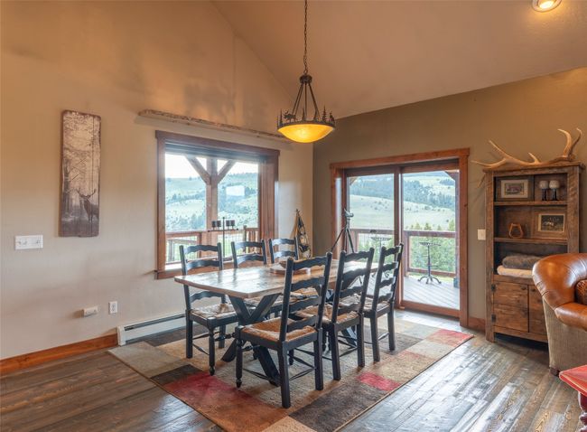 Dining area featuring a baseboard radiator, light wood-type flooring, high vaulted ceiling, and baseboards | Image 8