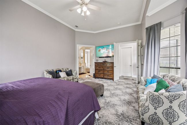 Bedroom with multiple windows, crown molding, a ceiling fan, and ensuite bath | Image 22