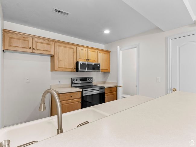 Kitchen featuring appliances with stainless steel finishes, light countertops, and recessed lighting | Image 7