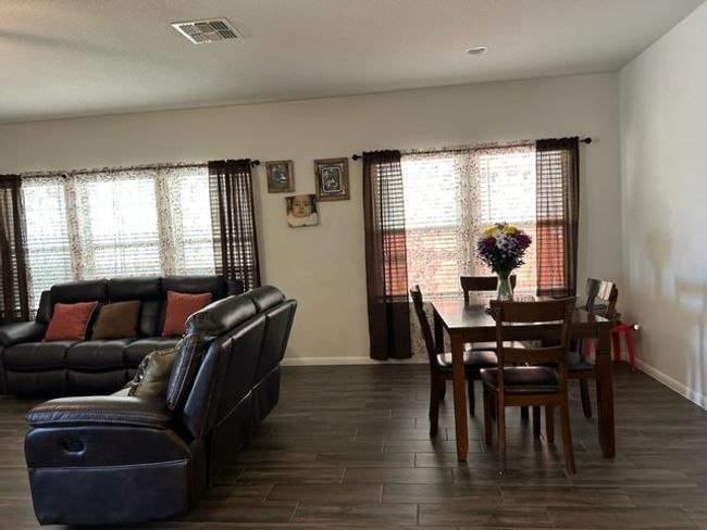 Dining area with visible vents, baseboards, dark wood-style flooring, and a healthy amount of sunlight | Image 14