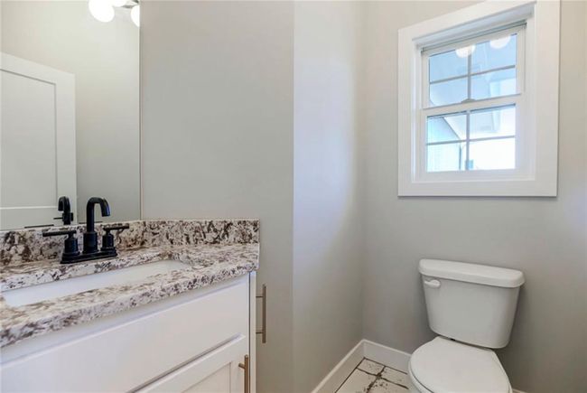 Half bath with baseboards, vanity, and toilet | Image 15