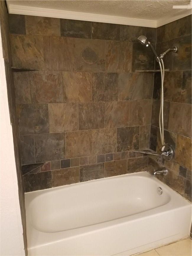 Full bath featuring shower / bathtub combination and a textured ceiling | Image 9